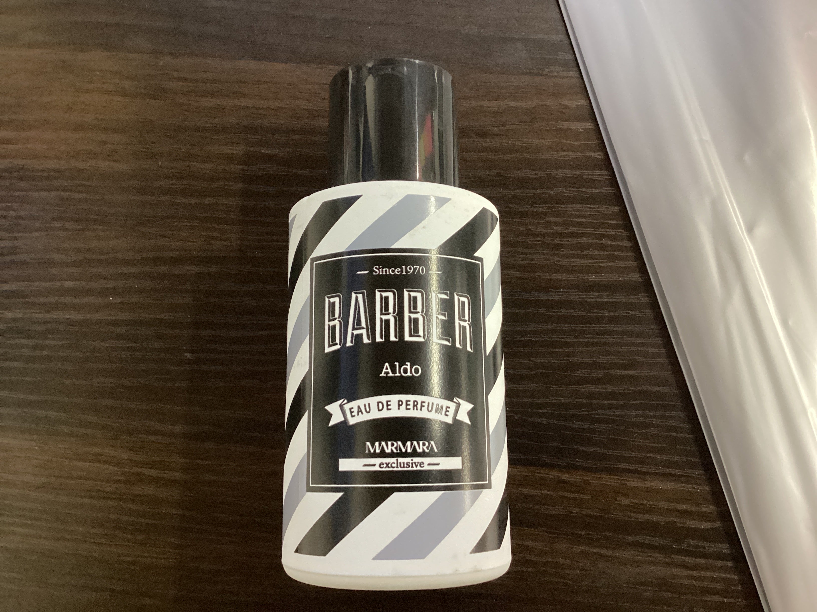 Bottle of Barber Aldo perfume on a wooden surface
