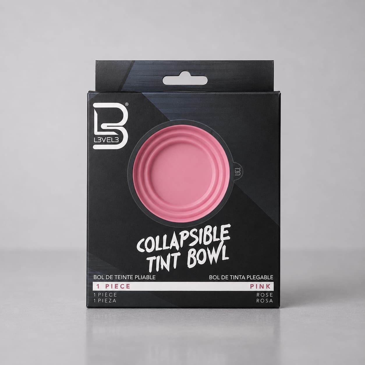 Black packaging of a collapsible tint bowl with pink bowl on a gray background