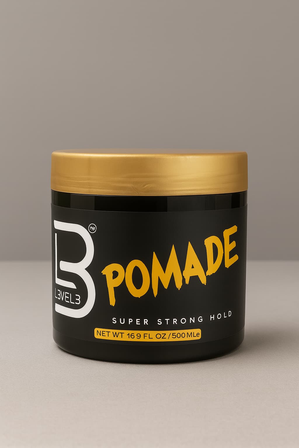 Jar of Level 3 Pomade with gold lid on a gray background