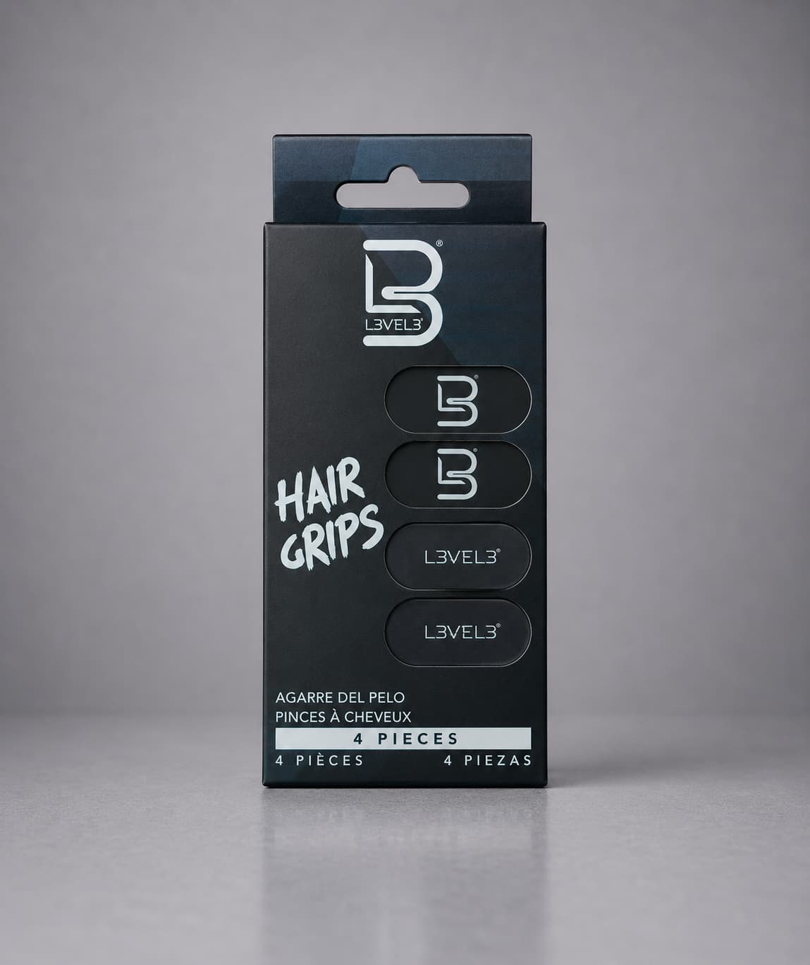 Black packaging of Level 3 hair grips on a gray background