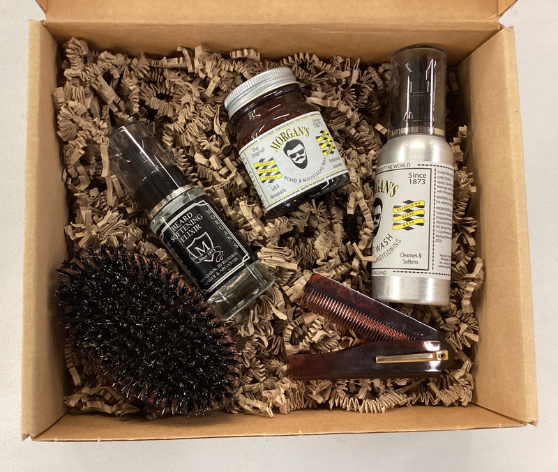 Set of grooming products including a brush, jar, and bottles in a box on a white background