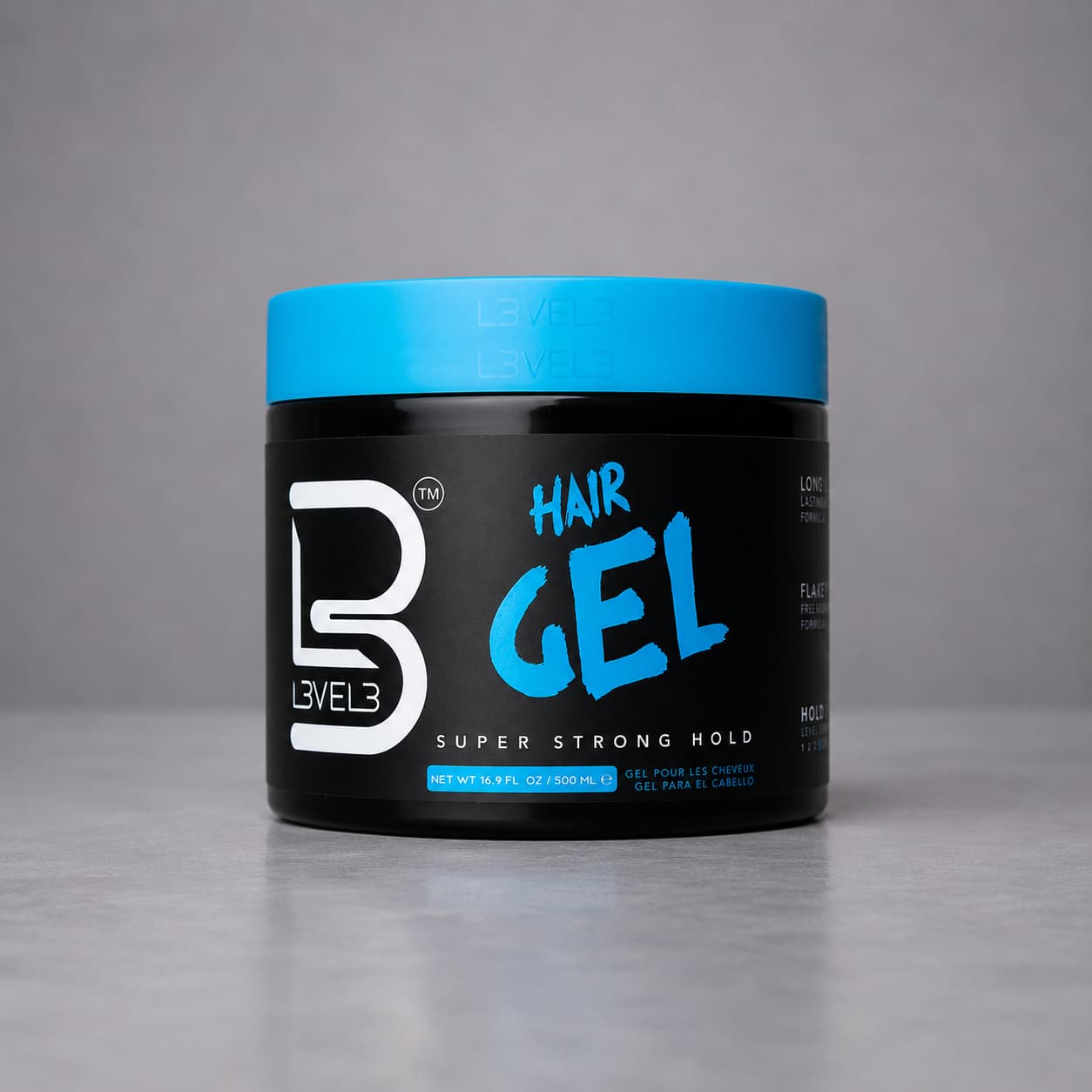 Black jar of Level 3 hair gel with blue lid on a gray background